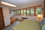 Lower level bedroom with queen bed, full wall of windows